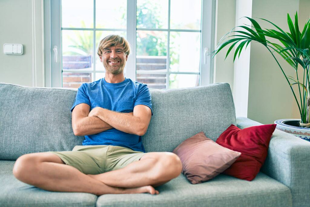 Middle age handsome caucasian man relaxing at sitting on the sofa at home - Photo, Image