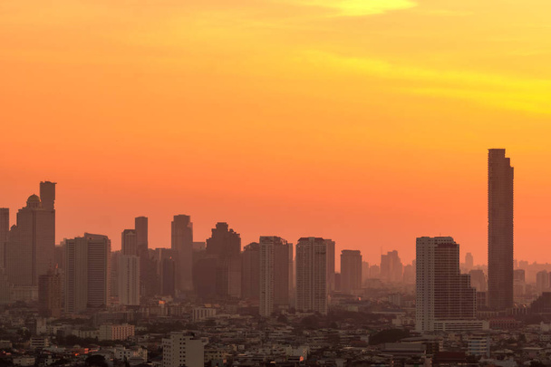 Luchtverontreiniging. Smog en fijn stof van pm2.5 overdekte stad in de ochtend met oranje zonsopgang hemel. Stadsgezicht met vervuilde lucht. Vieze omgeving. Stedelijk giftig stof. Ongezonde lucht. Stedelijk ongezond leven. - Foto, afbeelding