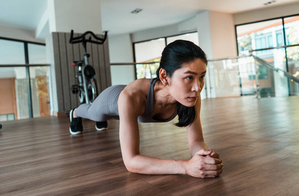 Slim fitness jeunes femmes faisant de l'exercice de planche dans la salle de gym - Photo, image