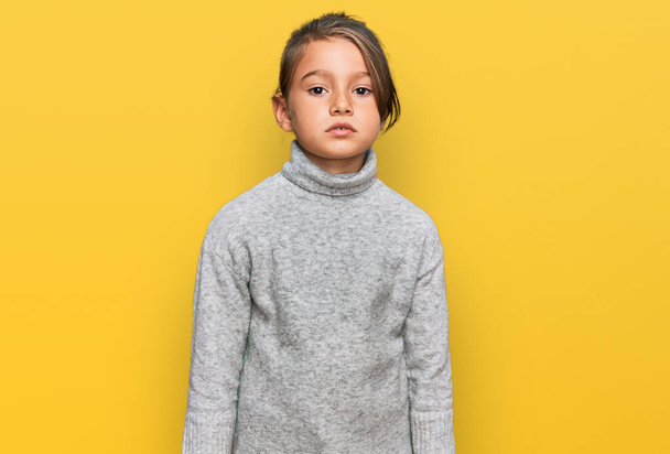 Little beautiful girl wearing casual turtleneck sweater with serious expression on face. simple and natural looking at the camera.  - Foto, Bild