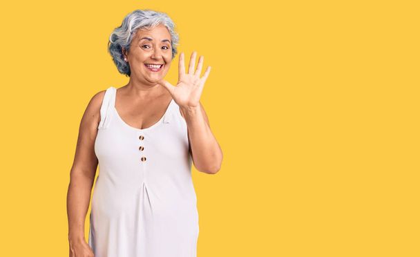senioren vrouw met grijs haar dragen casual kleding tonen en wijzen met vingers nummer vijf terwijl glimlachen zelfverzekerd en gelukkig.  - Foto, afbeelding
