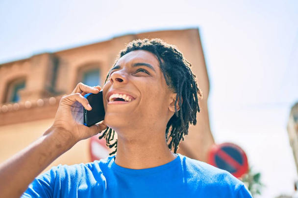 Young african american man smiling happy talking on the smartphone at street of city. - Foto, immagini