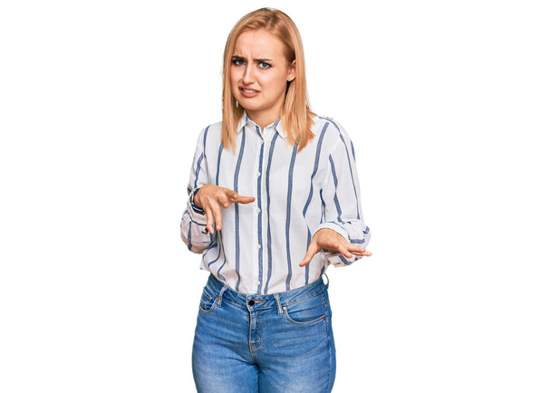 Beautiful caucasian woman wearing casual clothes disgusted expression, displeased and fearful doing disgust face because aversion reaction.  - Foto, Imagen