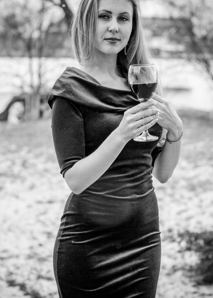 Egy nő egy pohár borral a természetben, retro kék ruhában. A problémás nők és az alkohol fogalma - Fotó, kép