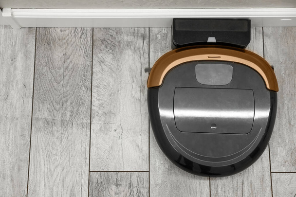 A modern robot vacuum cleaner stands at a charging station, top view. New technologies. - Фото, зображення