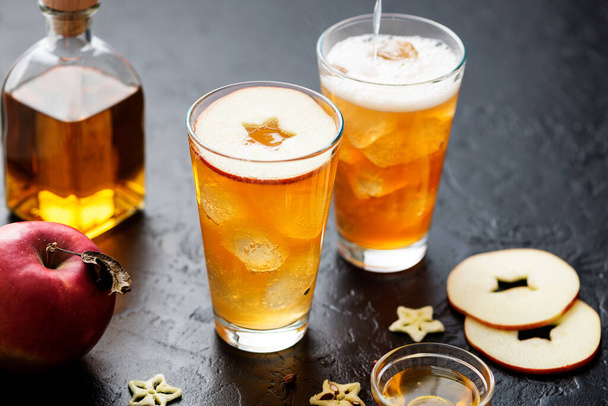 Ginger Beer and Honey Whiskey cocktail with ice cubes and red apple slices. - Photo, Image
