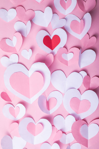 Valentine's Day festive background with pink and white paper hearts on a pink background for Valentines  holiday. Flatlay. Top view. Copyspace. - Photo, Image