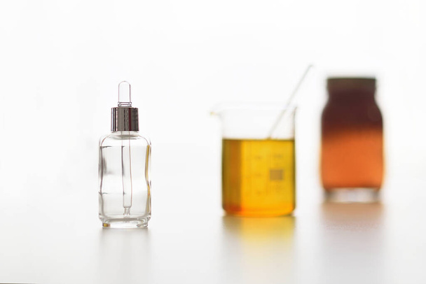 Prozess der Herstellung von natürlichem Elixier mit Pflanzenölen und leeren Flaschen auf weißem Hintergrund - Foto, Bild