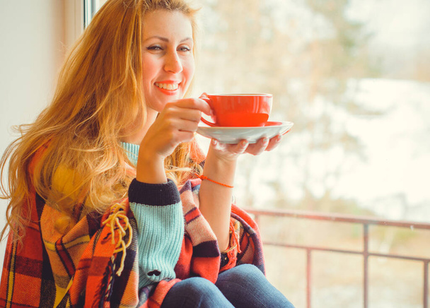 Мила жінка на самоізоляції, п'є гарячу каву, сидячи на вікні в затишному будинку. Концепція щастя і радісний спосіб життя, досить затишний ранок
 - Фото, зображення