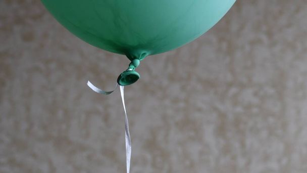 Globo de helio de color verde flotando en un fondo borroso con espacio de copia - Foto, imagen