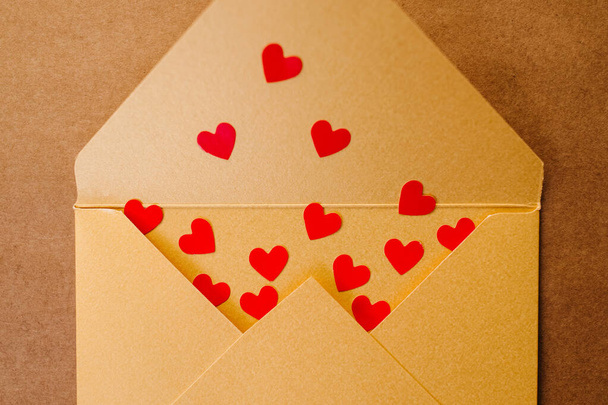 Открытый конверт, полный красных сердец, крупным планом. - Фото, изображение