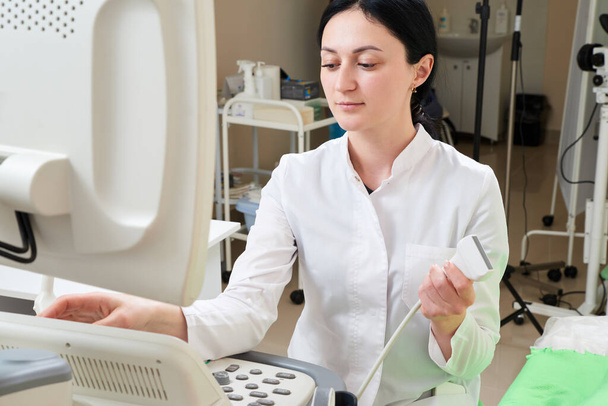 Gynecologist doing ultrasound scan in modern clinic - Фото, зображення