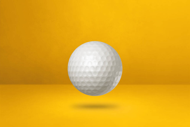 White golf ball isolated on a yellow studio background. 3D illustration - Foto, Imagen
