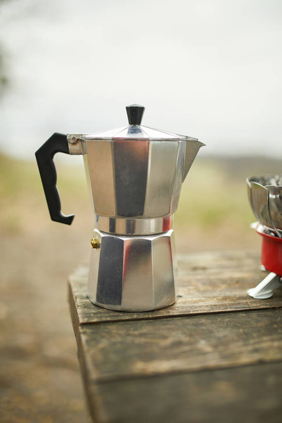 Prozess der Herstellung von Camping-Kaffee im Freien mit Metall-Geysir-Kaffeemaschine auf einem Gasbrenner, Schritt für Schritt. Reiseaktivitäten für Entspannung, Buschboot, Abenteuer, Reisen, Tourismus und Campingkonzept - Foto, Bild