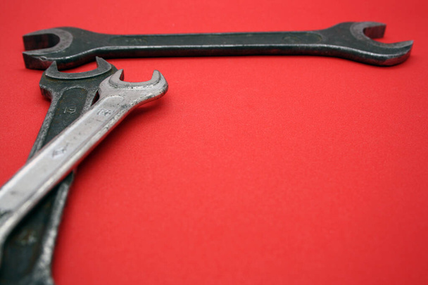 A set of wrenches of different sizes on a red background. - Фото, изображение