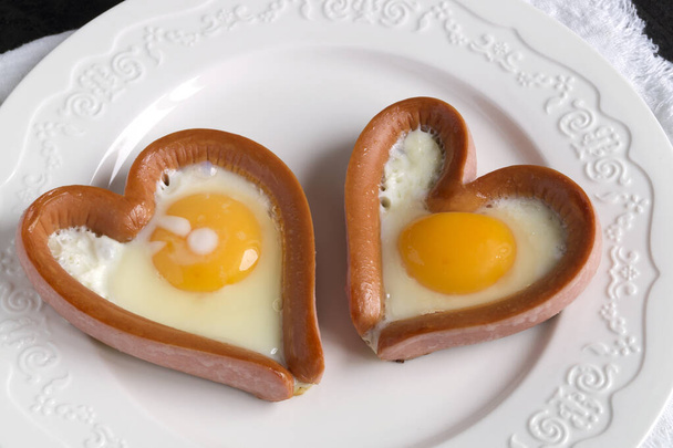 valentine's day breakfast. sausage with scrambled egg in the shape of a heart. - Photo, Image