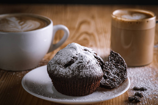 Selective focus, low key, Classic espresso, coffee with coffee chip muffin with coffee beans on an old wooden table. Morning coffee. Top view. - 写真・画像