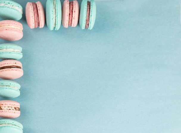 Macarons colorés et sucrés sur fond bleu, avec espace de copie. - Photo, image