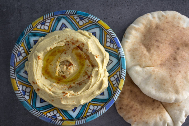 Top view photo of hummus plate. Middle Eastern food. Healthy eating concept. Grey background with copy space. - Photo, Image