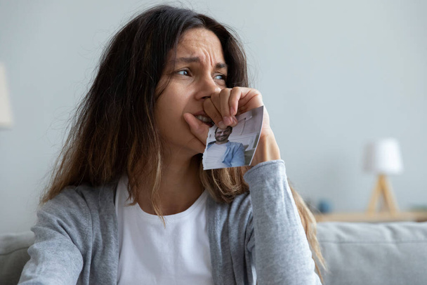 Close up crying woman holding picture of husband, break up - Fotó, kép