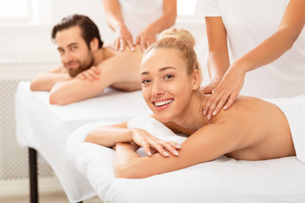 Conjoints joyeux recevant relaxant massage du dos allongé à l'intérieur - Photo, image