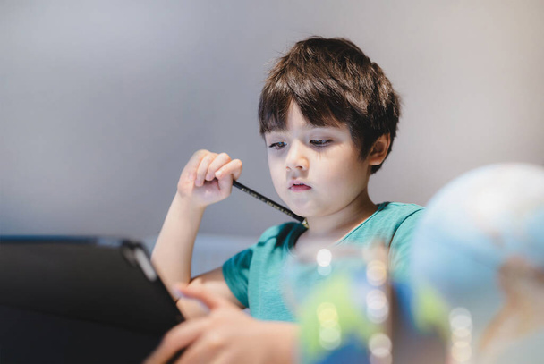 子供の宿題のためのタブレットを使用して自己分離,子はcovid 19ロックダウン中にインターネット上でデジタルタブレット検索情報を使用して行う,家庭教育,社会的距離, e-ラーニングオンライン教育 - 写真・画像