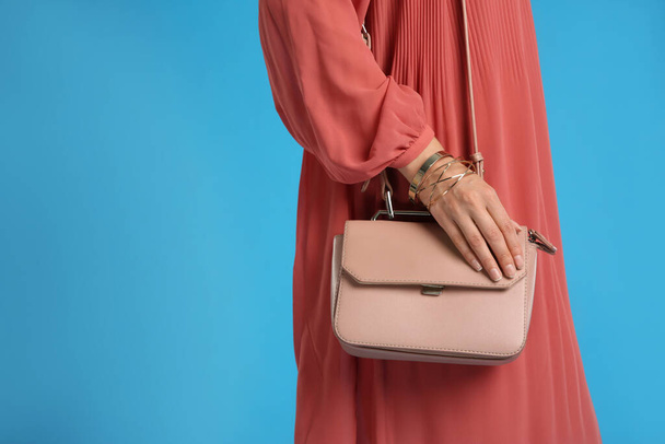 Young woman with stylish pink bag on light blue background, closeup. Space for text - Fotografie, Obrázek