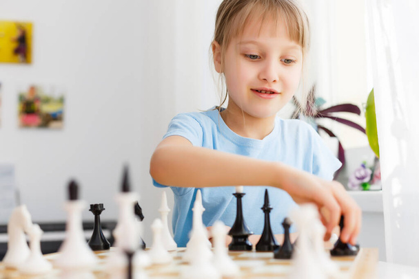 Девушка двигает счетчик во время игры в шахматы - Фото, изображение