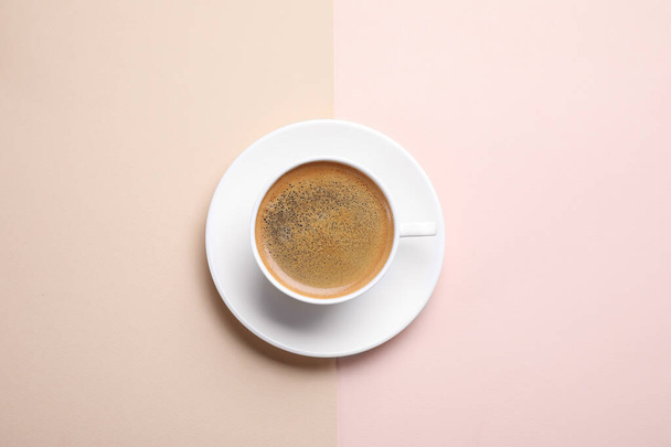 Beker van aromatische koffie op kleur achtergrond, bovenaanzicht - Foto, afbeelding