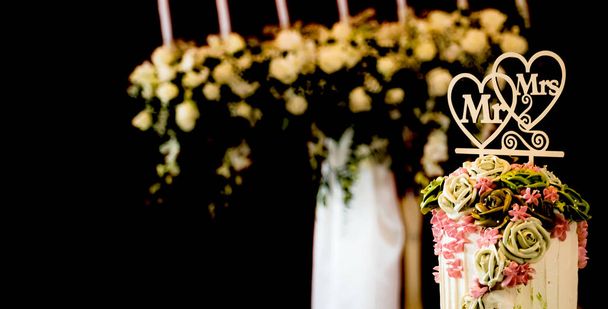 Fleur rose sur gâteau de mariage pour le couple marié et marié coupé dans l'événement de fête de mariage dans un restaurant ou une église. - Photo, image