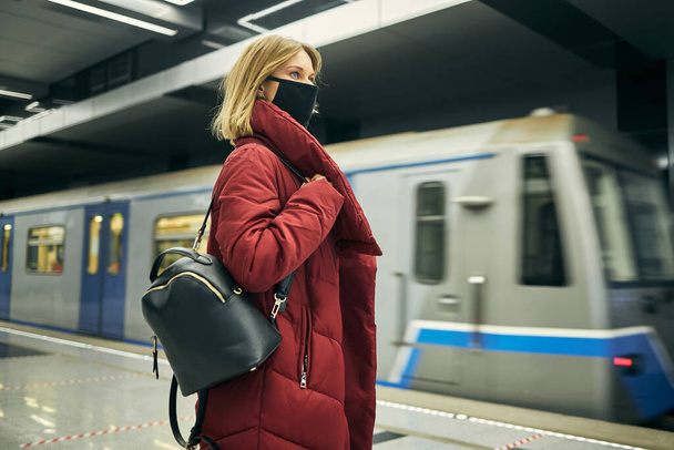 girl in a medical mask is waiting for her train - Zdjęcie, obraz