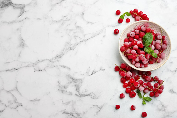 Tasty frozen red currants on white marble table, flat lay. Space for text - Foto, Imagem