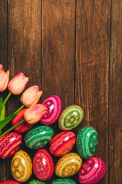 Coloridos huevos de Pascua sobre fondo de madera. Feliz Pascua. Espacio para texto. - Foto, imagen
