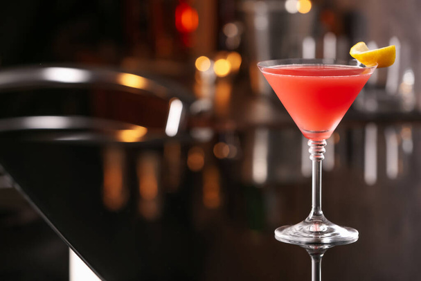 Cosmopolitan cocktail on black table in bar. Space for text - Φωτογραφία, εικόνα