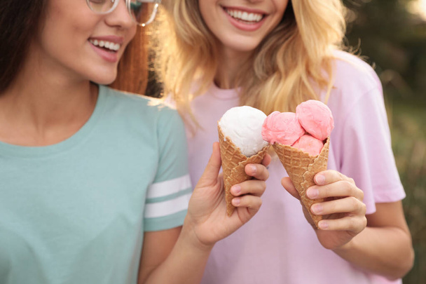 Young women with ice cream spending time together outdoors - Foto, imagen