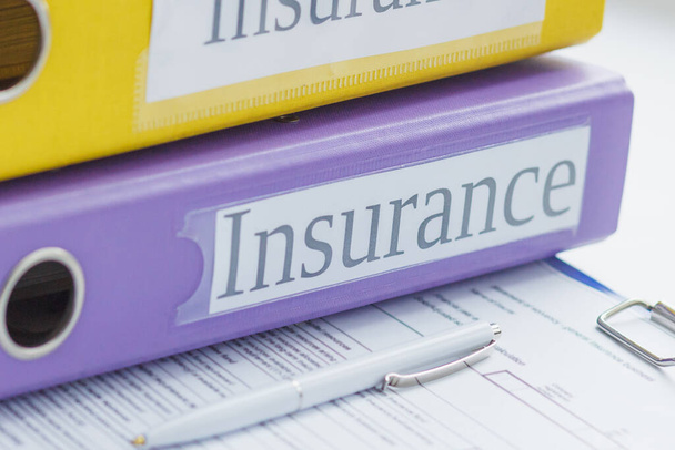 Clean insurance form, colored folders and a pen, soft focus background - Foto, Bild