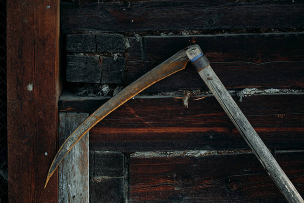 Na dřevěné stěně visí starý rezavý kovový cop. - Fotografie, Obrázek