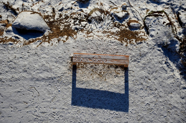 New massive benches in the woods on a lookout of larch wooden beams. screwed and fixed to the ground. sunken with snow. view from drone, side view. sunny, dusting snowfall - Photo, Image