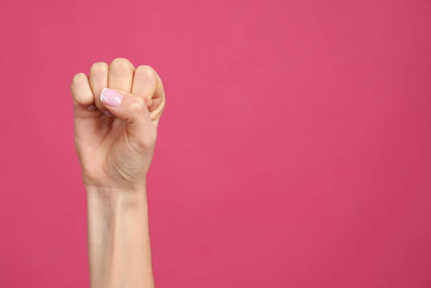 Closeup view of woman showing fist as girl power symbol on pink background, space for text. 8 March concept - Fotó, kép