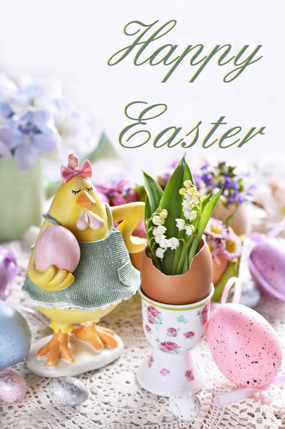 Easter greeting card with funny hen figurine and spring flowers in egg shells on festive table - Foto, Imagem