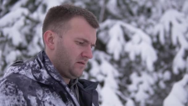 Un guapo bloguero masculino se está preparando para ir en vivo durante un viaje al norte de Rusia en invierno en el bosque nevado - Imágenes, Vídeo