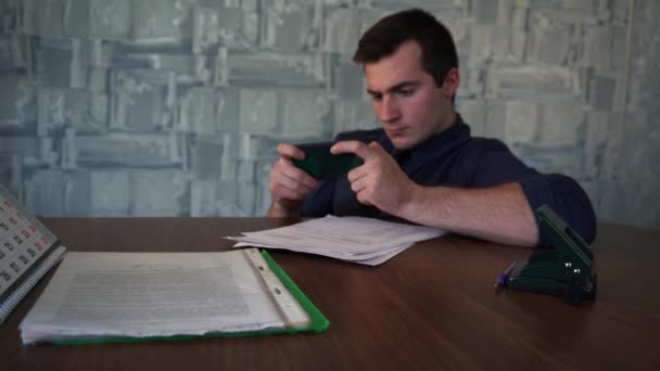 verrast man gebruikt telefoon zitten aan een tafel uit focus - Video