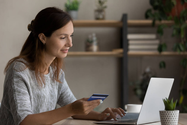 Millennial female client shopping online with credit card - Foto, imagen