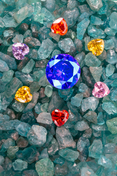 青いサファイアダイヤモンドは、青い空の宝石の上にカラフルなハート型のダイヤモンドの飛び地に配置されます - 写真・画像
