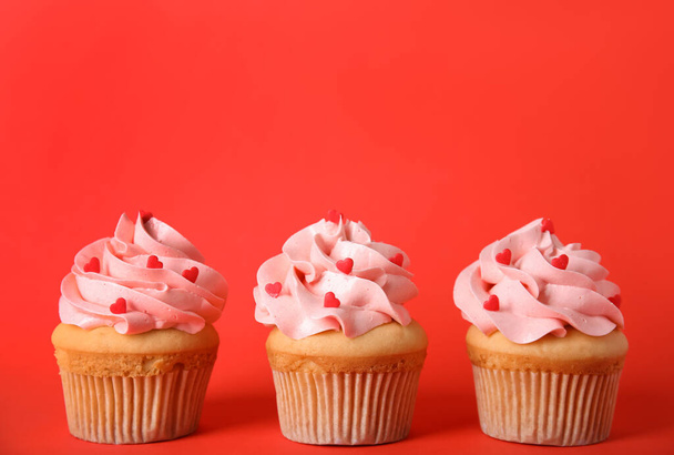 Row of tasty cupcakes on red background, space for text. Valentine's Day celebration - Zdjęcie, obraz