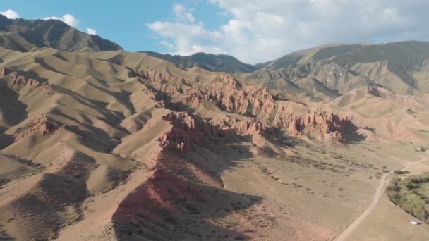 Αεροφωτογραφία των κόκκινων βουνών. Ο δρόμος κατά μήκος του πυθμένα του φαραγγιού πέρα από τα κόκκινα βουνά. Τουριστική θέση στα βουνά στο οροπέδιο Asy. - Πλάνα, βίντεο