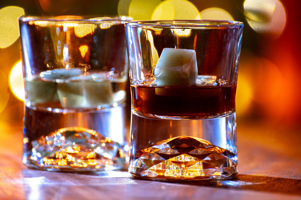 Sklenice z čistého sladu a míchané skotské whisky podávané v baru v Edinburghu, Skotsko, Velká Británie se světly na pozadí - Fotografie, Obrázek