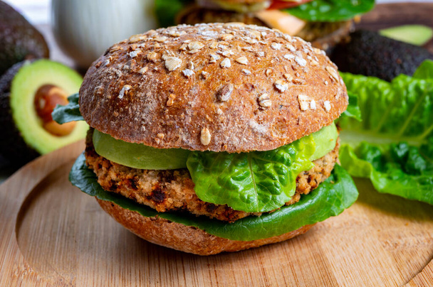 Tasty vegetarian healthy green food, homemade burgers made from orange lentils legumes with green lettuce and fresh ripe avocado - Foto, immagini