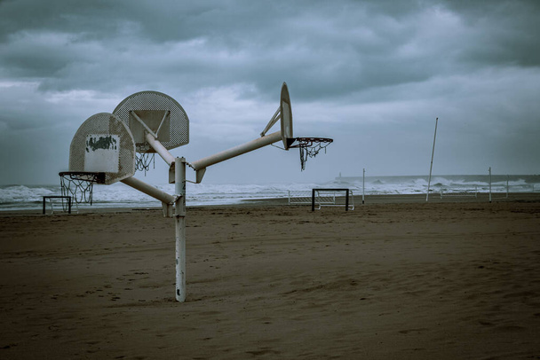 Basketballkörbe am einsamen Strand an einem Wintertag mit bewölktem Himmel.. - Foto, Bild