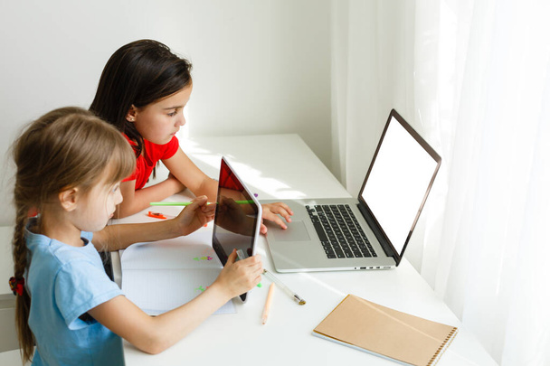 Evde öğreniyorum, evde öğreniyorum. Küçük çocuklar evde bilgisayarla online öğrenim görüyorlar. Karantina ve Sosyal Mesafe. - Fotoğraf, Görsel